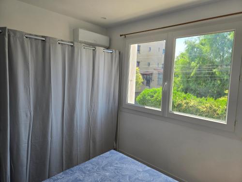 a room with a window and a shower curtain at Yamna in Perpignan