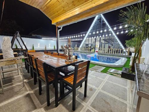 a patio with a table and chairs and a pool at Dreamvilla aframe in Gabala