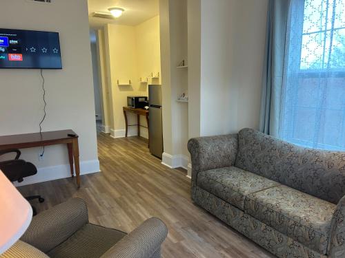 a living room with a couch and a tv at The Inn at Cedar Grove in Vicksburg