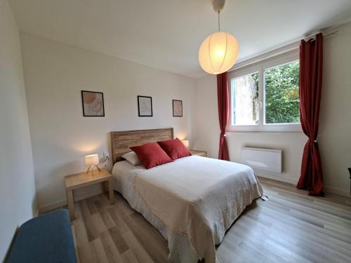 a bedroom with a bed with red pillows and a window at Maison de campagne - Granges sur Lot in Granges-sur-Lot