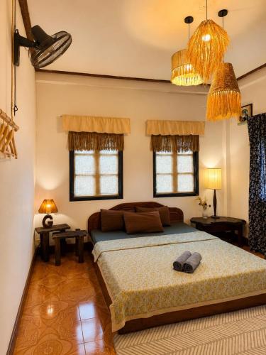 a bedroom with a bed and two windows at MI CASA Luang Prabang in Luang Prabang