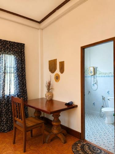 a room with a table and a toilet and a mirror at MI CASA Luang Prabang in Luang Prabang