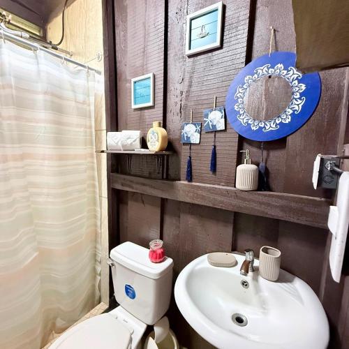 a bathroom with a toilet and a sink at La Cabaña de Don Tavo in Roble