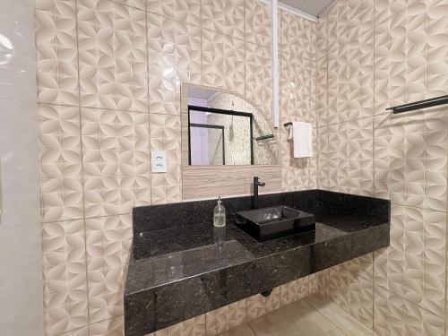 a bathroom with a black sink and a mirror at Completa e próxima ao Acqualinda in Andradina