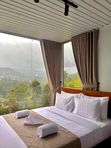 a bedroom with a large bed with a large window at RuKu Villa Pussellawa in Pussellawa