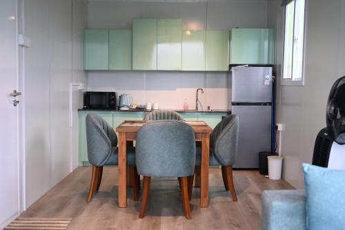 a kitchen with a table and chairs and a refrigerator at RuKu Villa Pussellawa in Pussellawa