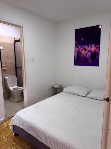 ein Schlafzimmer mit Bett und ein Badezimmer mit Toilette in der Unterkunft Hotel San Telmo in Buga