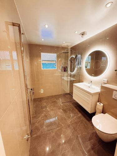 a bathroom with a shower and a toilet and a sink at Villa lugn och ro in Gustavsberg