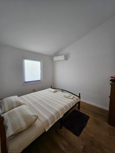 a bedroom with a large bed with a window at Gabi in Ðuraševići
