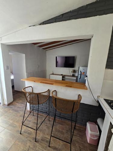 a kitchen with two chairs and a bar in a room at La Chiquitita apart in San Fernando del Valle de Catamarca