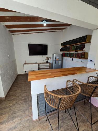 a kitchen with two chairs and a counter with a television at La Chiquitita apart in San Fernando del Valle de Catamarca