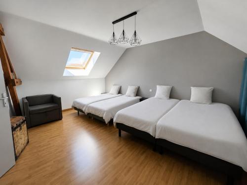 a bedroom with two beds and a chair at La Clé des Vignes 3 in Roye