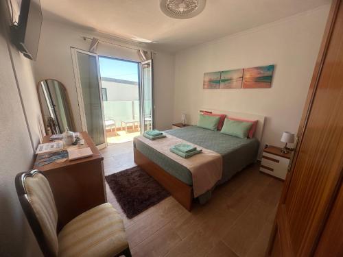 a bedroom with a bed and a large window at Gori House in Madalena do Mar