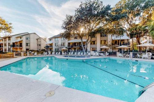 a swimming pool at a hotel with tables and chairs at Springwood Villas 51 in Hilton Head Island
