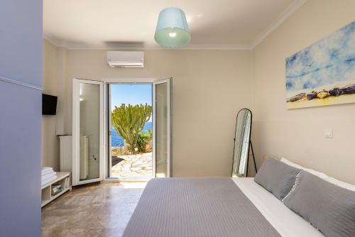 a bedroom with a bed and a view of the ocean at Syros Private House with superb sea view in Kini