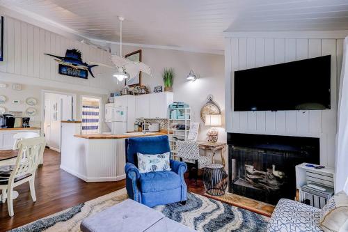 a living room with a blue chair and a fireplace at Driftwood Villa - 269 in Edisto Island