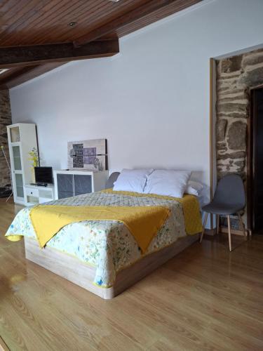 a bedroom with a bed and a desk and a chair at Cabana Toxosoutos in Tojos Outos
