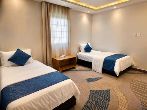 a hotel room with two beds and a window at Elaf Al Sharqyah Hotel -Alaziziah فندق ايلاف الشرقية العزيزية in Al Khobar