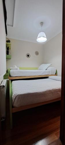 a bedroom with two beds and a light at Apartamento Marichu in Melide
