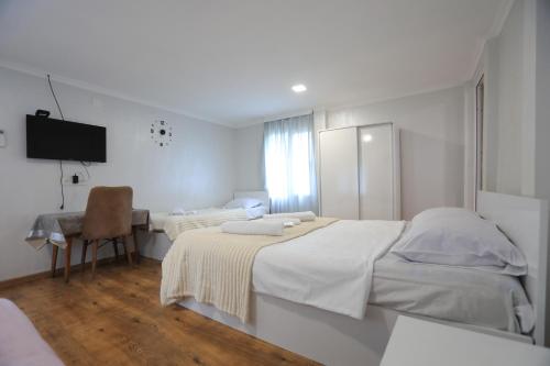 a white room with two beds and a desk at BANI tsikhisdziri in Ts'ikhisdziri