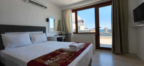 a bedroom with a bed and a large window at Grand Peninsula Hotel in Istanbul