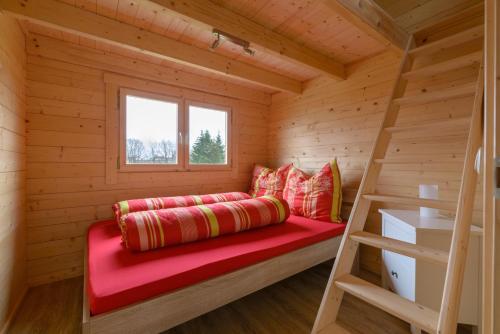 Una cama en una cabaña de madera con una escalera en Chalets am National Park Eifel en Schleiden