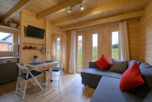 ein kleines Wohnzimmer mit einem Sofa und einem Tisch in der Unterkunft Chalets am National Park Eifel in Schleiden