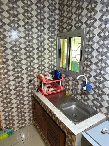 a kitchen counter with a sink and a window at Residence samy in San-Pédro