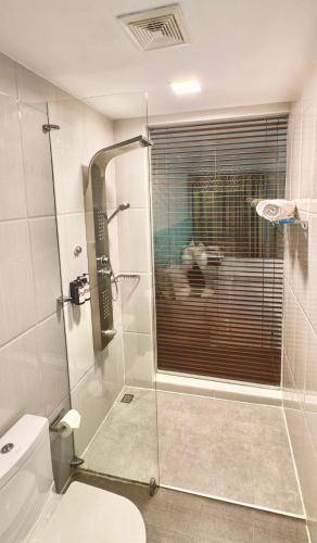 a bathroom with a toilet and a glass shower at LVIS blancura Hotel in Dharavandhoo