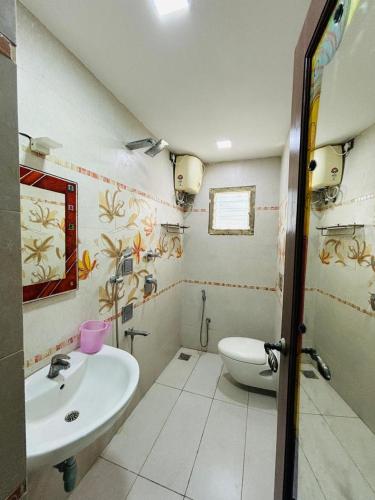 a bathroom with a sink and a toilet at Villa Clasic Comfort in Navalur