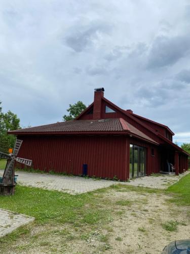 a red barn with a red roof at Suur ja Hubane maja, Saaremaal in Saareküla