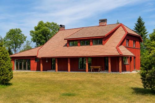 a red house with a red roof at Suur ja Hubane maja, Saaremaal in Saareküla