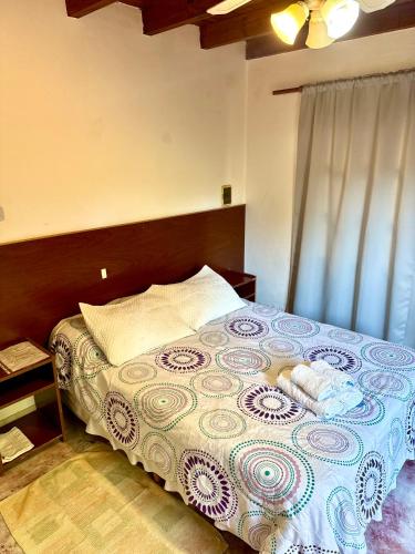 a bedroom with a large bed with a wooden headboard at Hostal Andino - Adults Only in Cafayate
