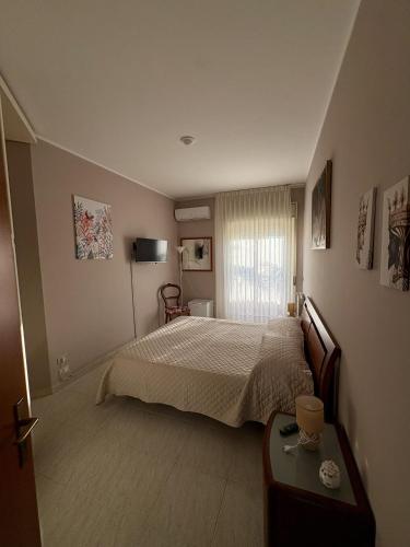 a bedroom with a bed and a table and a window at Casa Calipa in Marsala