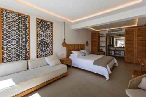a bedroom with a bed and a couch at Thalassa boutique hotel-Adults only in Platis Gialos