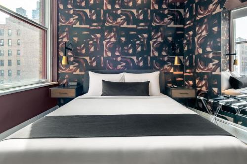 a bedroom with a bed and a black and white wall at Flatiron Studio Near Madison Square Park in New York