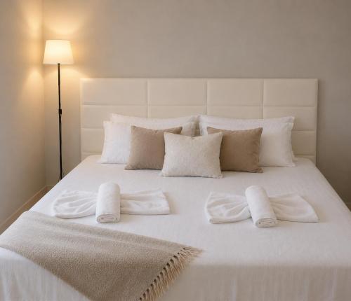 a white bed with white towels and pillows on it at Epanomi apartment in Epanomi