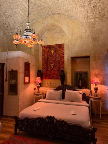a bedroom with a large bed and a chandelier at antik senyora butik in Urfa