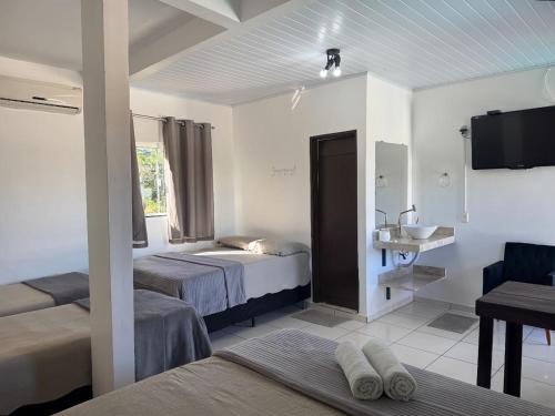 a hotel room with two beds and a sink at Pousada Sunflower in Pirenópolis
