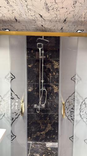 a shower in a bathroom with a black wall at antik senyora butik in Urfa