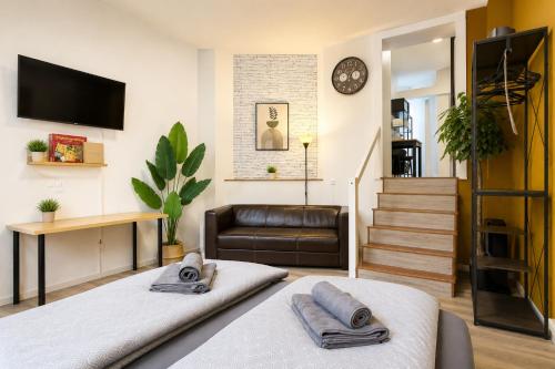 a living room with a bed and a couch at Beesenkammer - zentrales StudioApartment Halle in Halle an der Saale