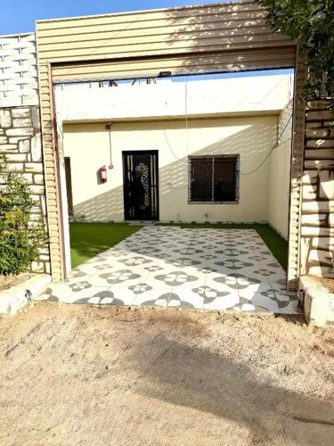 a garage with a black door and a tile driveway at شاليهات زارا 2 in Taif