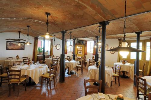 a dining room with white tables and chairs and a room with at Agriturismo Cavazzone in Regnano