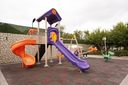 a playground with two slides and a slide at Forelle Restaurant & Motel in Çuxuryurd