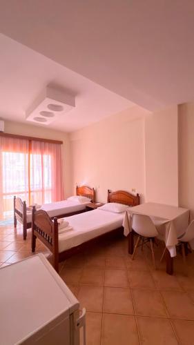 a room with three beds and a table at Vila Papa in Durrës