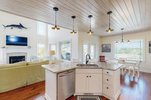 a kitchen with a sink and a living room at Sweet Carolina in Edisto Island