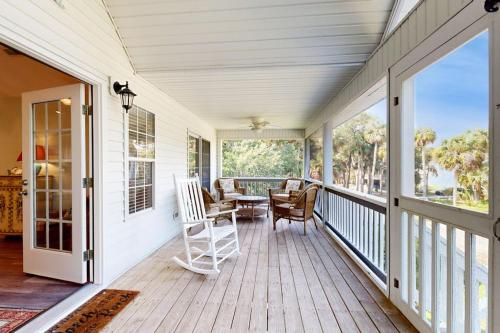 a porch with a table and chairs on it at Pompano End in Edisto Island