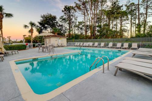 a swimming pool with chairs and a table at HH Beach & Tennis 344B in Hilton Head Island