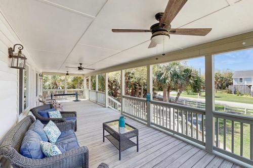 a porch with two couches and a ceiling fan at Feeling Tip'Sea in Edisto Island