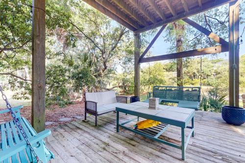 a patio with a table and chairs on a deck at Natural Wonder in Edisto Island